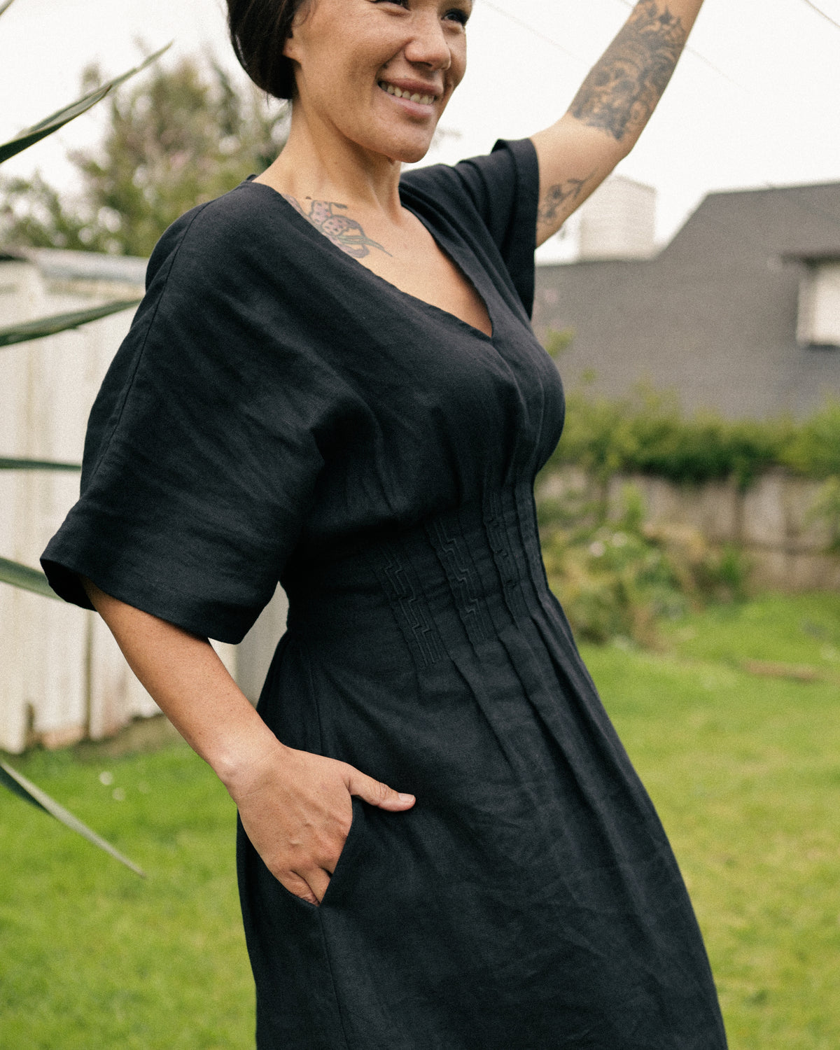 Winnie black linen maxi dress – front view in the garden, hand in pocket