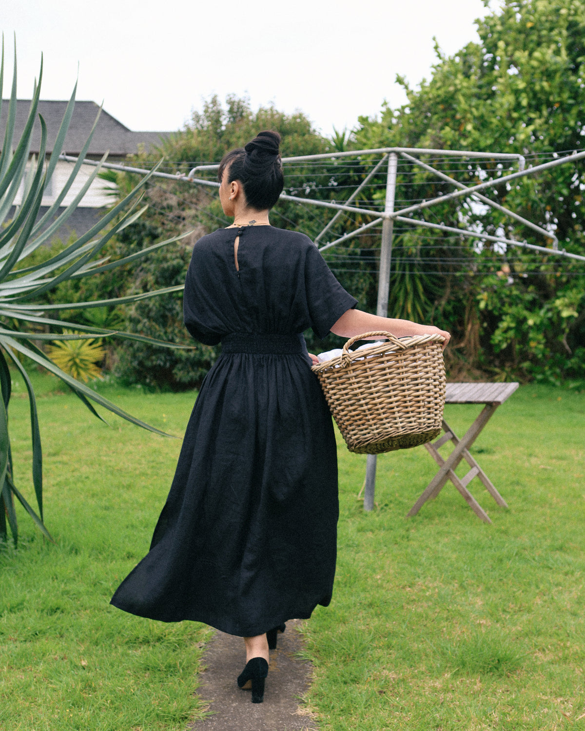 Winnie black linen maxi dress – back view in the garden